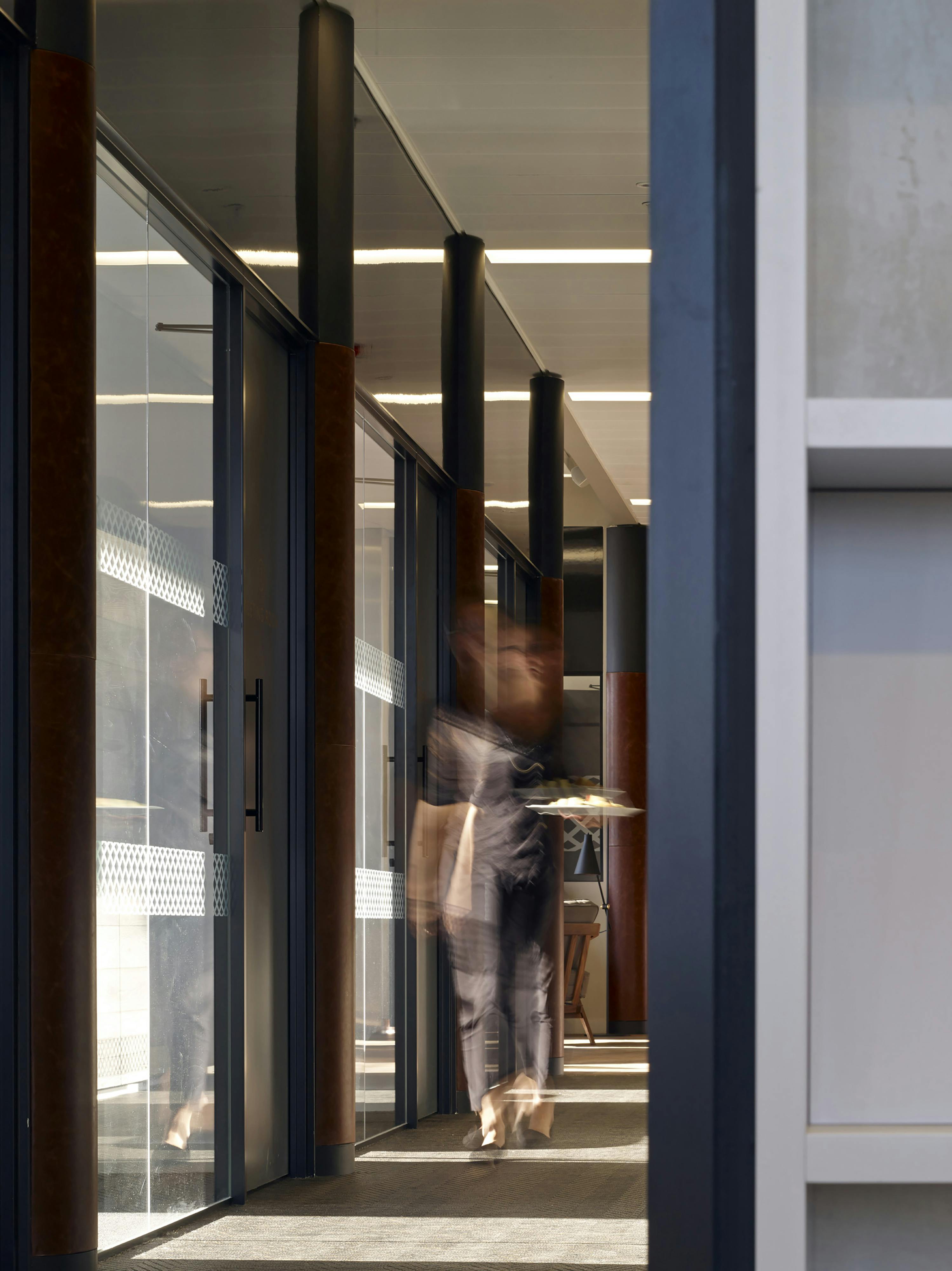 co-worker walking through office hallway carrying plate of food